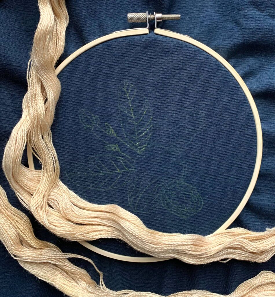 Walnut dyed embroidery thread against dark blue fabric
